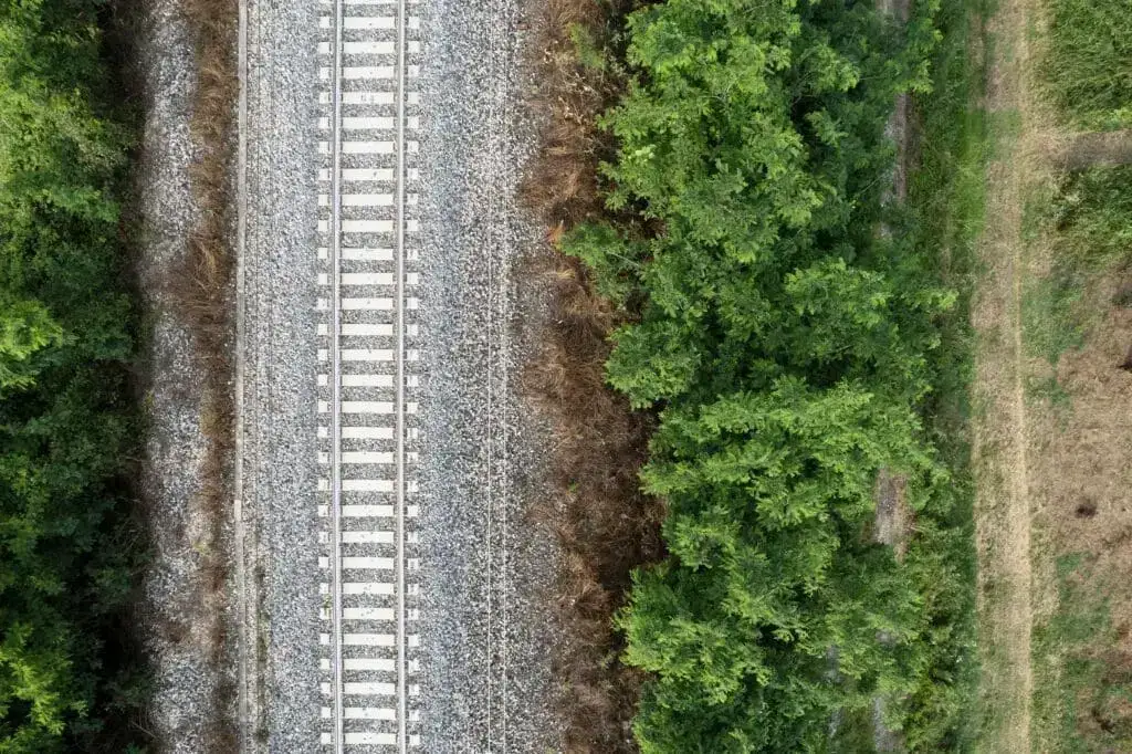 Aerial view of a rail corridor with vegetation along the track