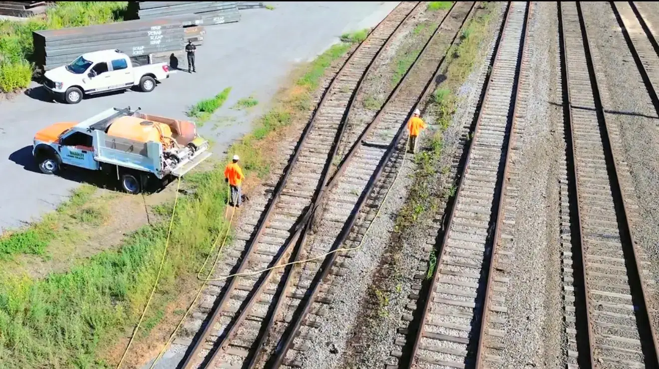 Crew spraying vegetation along an active rail corridor
